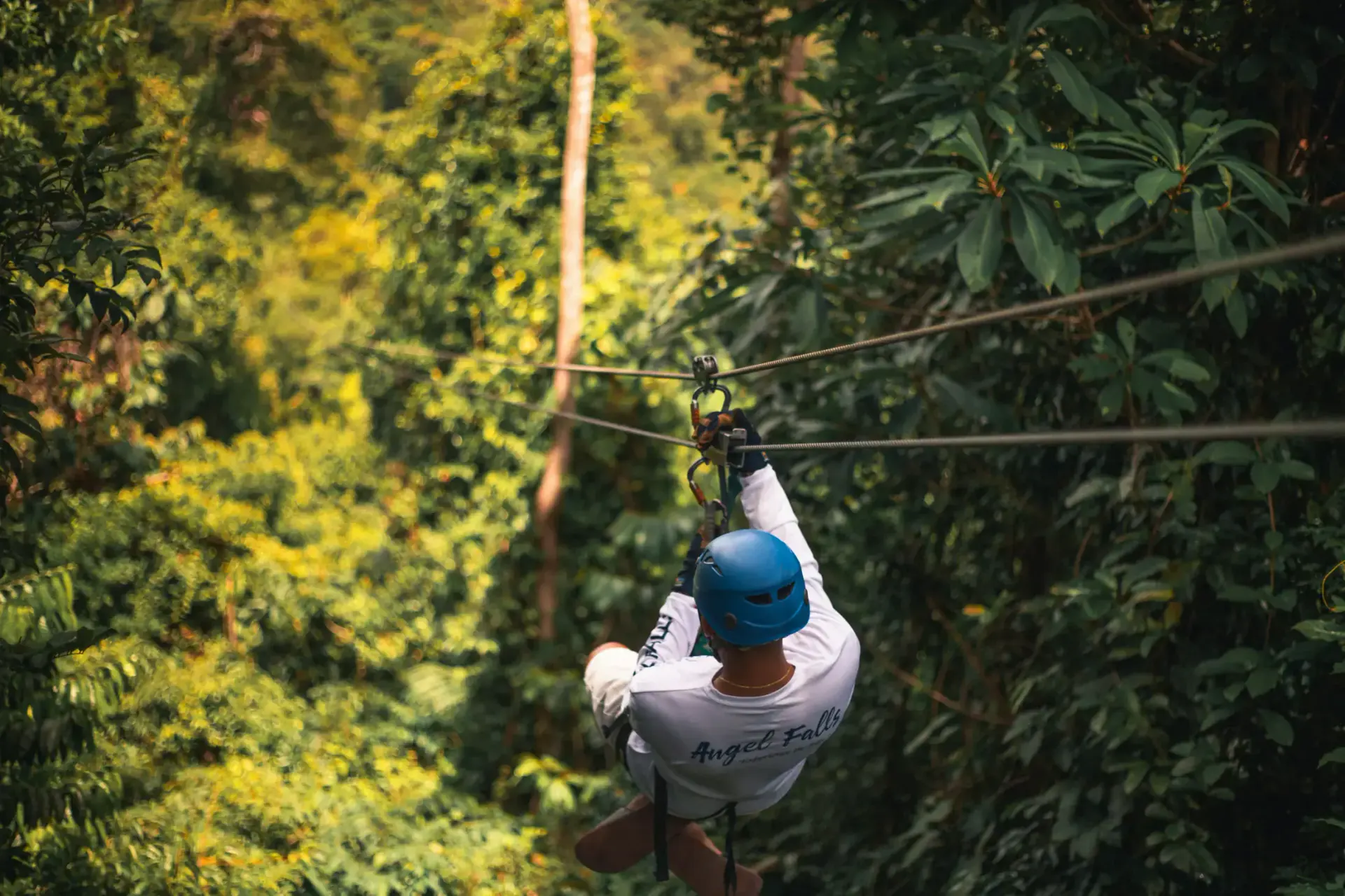 Traveler ziplining through Belize rainforest canopy